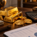 Gold bars and gold coins representing the hidden costs of buying, storing, and selling physical gold.